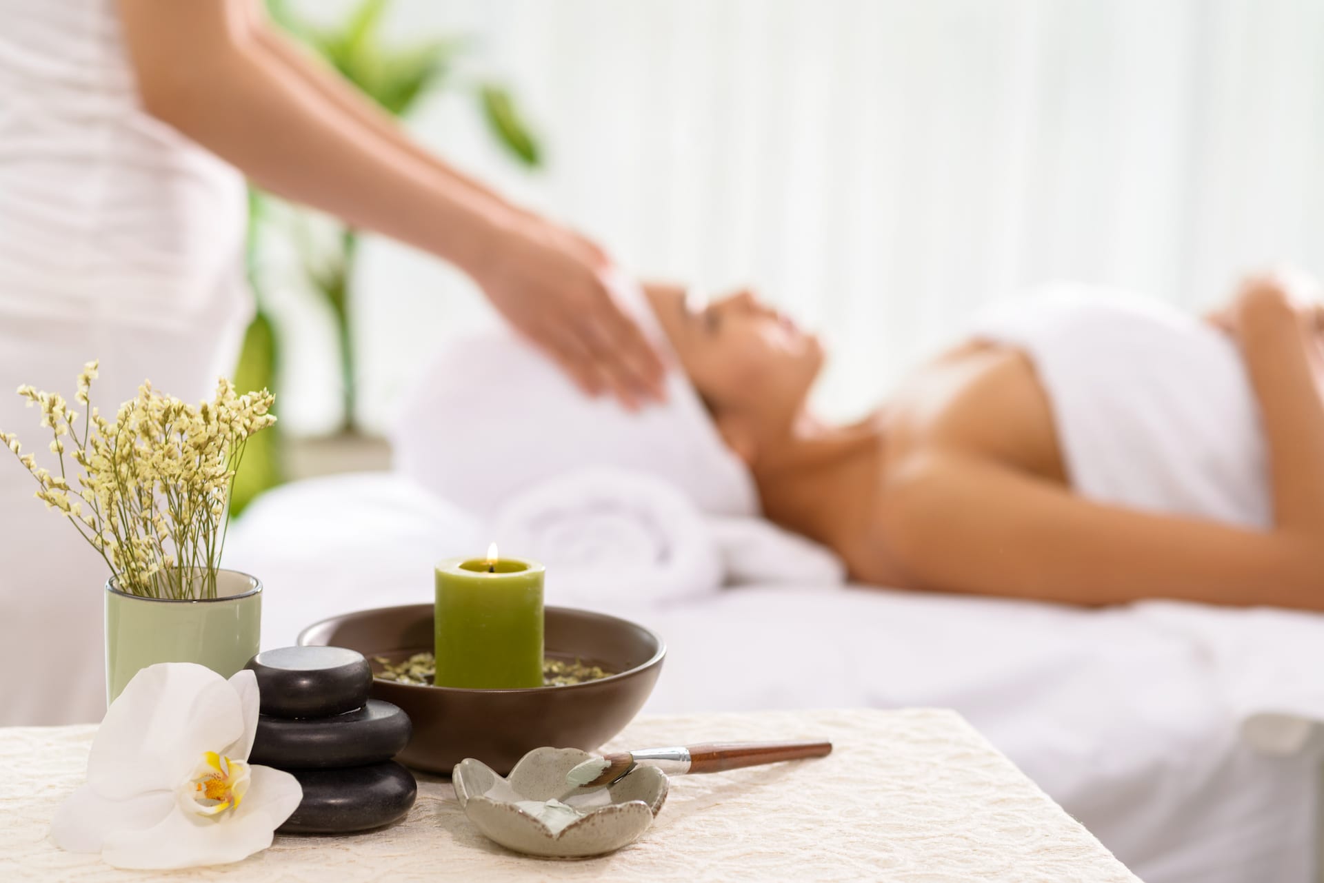 Spa accessories and a woman receiving spa treatment in the background