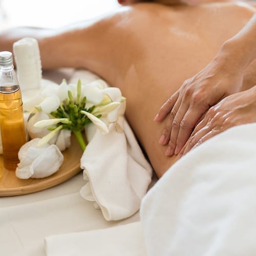 Young beautiful Asian woman sleep relaxing in the Oil spa massage in salon. Select focus hand of masseuse