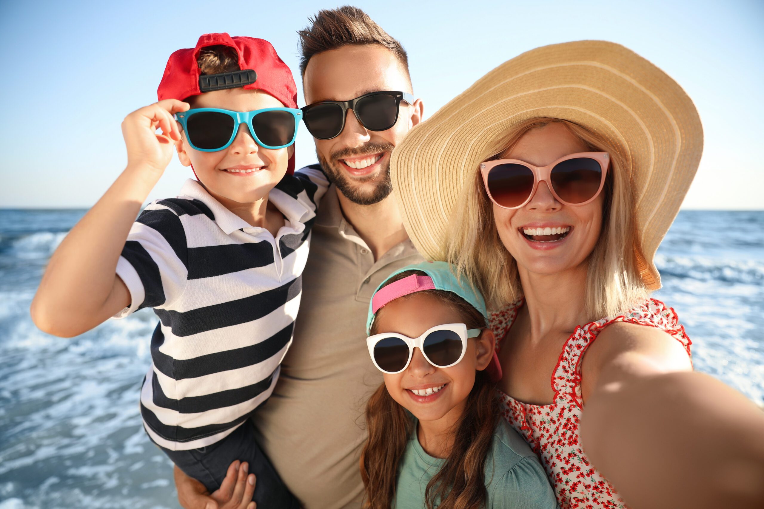 Happy family taking selfie on beach near sea. Summer vacation August Endless Summer Escape Sale